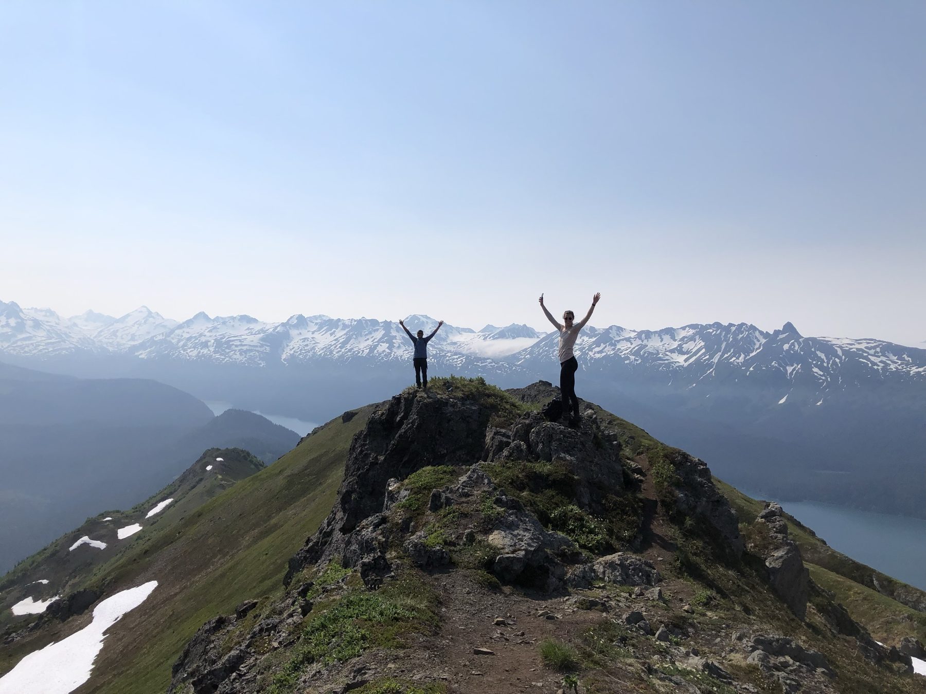 Hikers celebrating on the Grace Ridge summit with panoramic mountain views