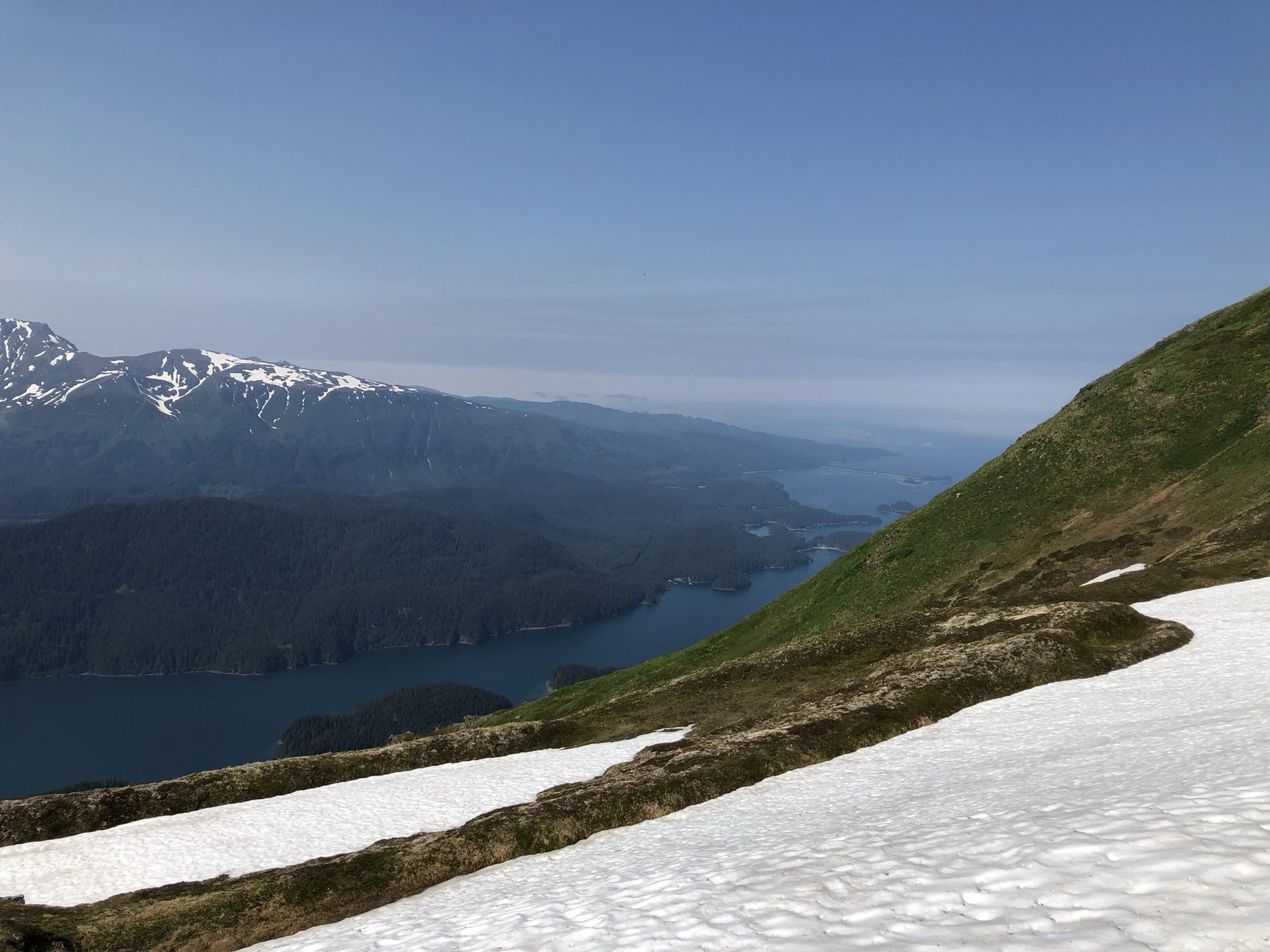 Ridge trail on Grace Ridge with snow patches above Kachemak Bay