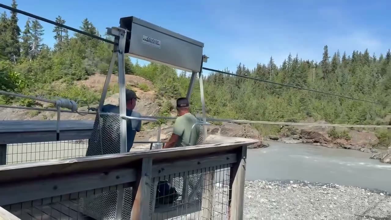 Two men operating the hand-pulled tramway across Grewingk Glacier Lake outflow